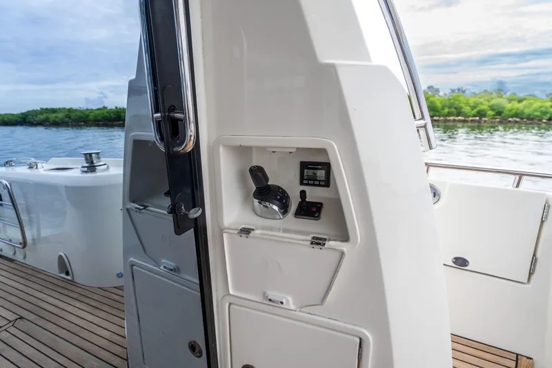 Slide: The Image of 2018 Prestige 520S yacht cockpit with control panel, overlooking serene water and lush greenery. - 29
