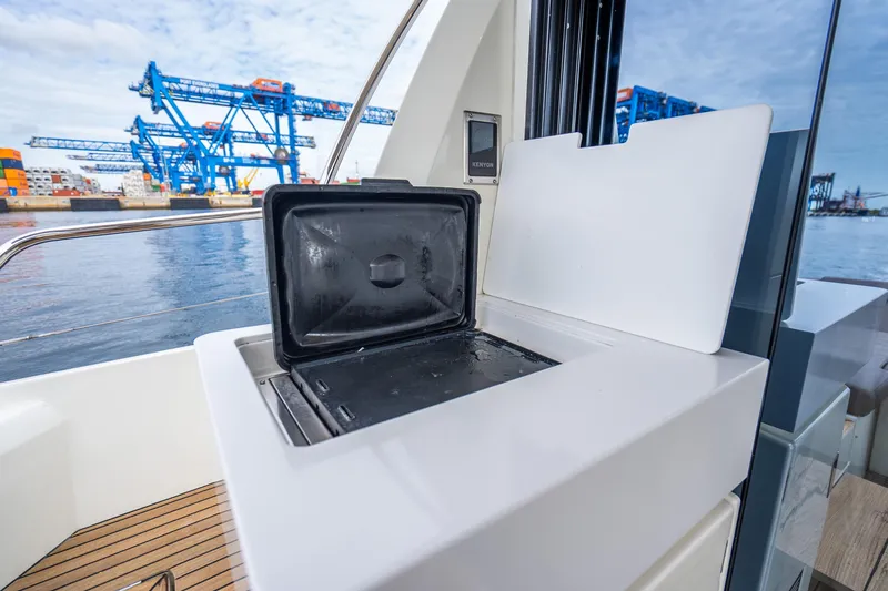 Slide: The Image of 2018 Prestige 520S yacht with open grill, dockside view, blue cranes in background. - 32