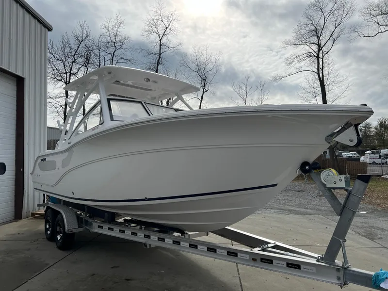 Slide: The Image of 2024 Sea Fox 268 Traveler boat on trailer, parked outdoors near a building. - 2