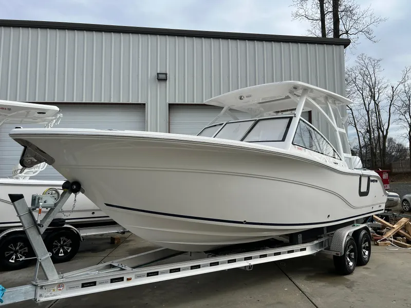Slide: The Image of 2024 Sea Fox 268 Traveler boat on trailer, parked outside a warehouse. - 3