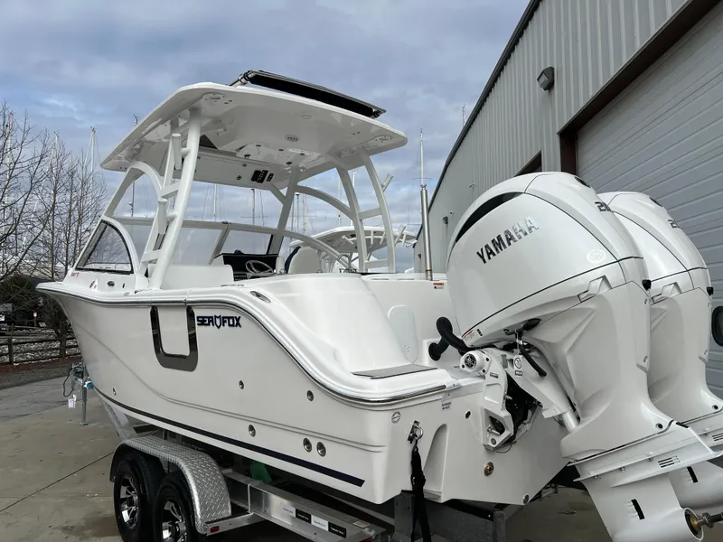 Slide: The Image of 2024 Sea Fox 268 Traveler boat with Yamaha engine, parked outside a warehouse. - 5