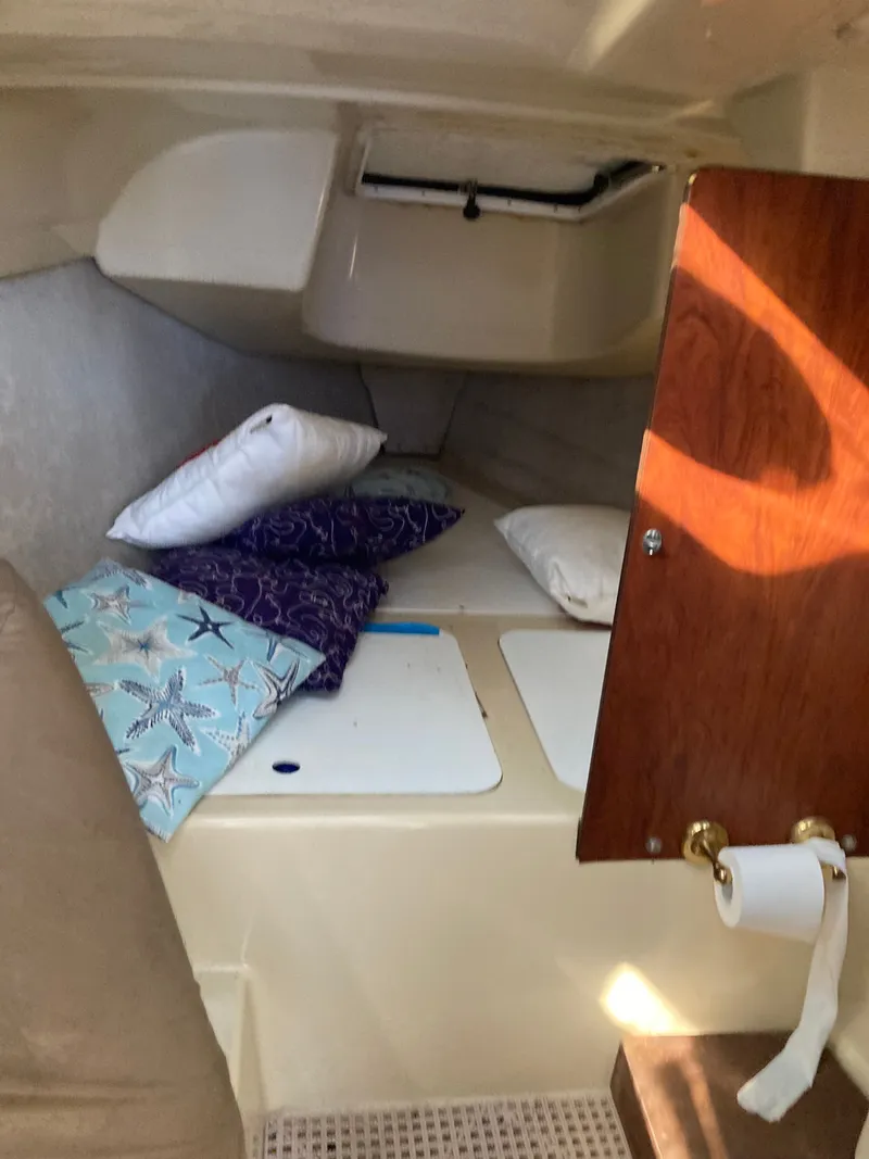 Slide: The Image of Interior of a 2007 MacGregor 26 yacht with cushions and wooden details. - 15