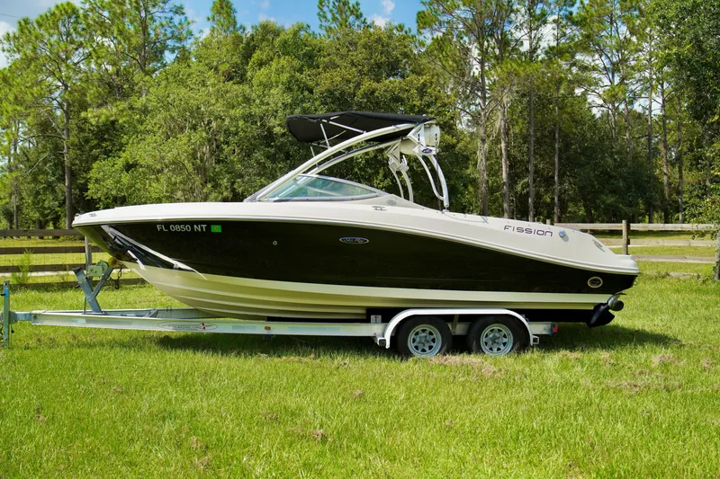 Slide: The Image of 2008 Sea Ray 230 Select Fission boat on a trailer in a grassy area. - 2
