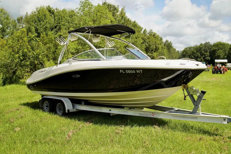 Slide: The Image of 2008 Sea Ray 230 Select Fission boat on a trailer in a grassy field. - 5