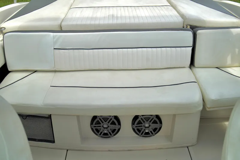 Slide: The Image of 2008 Sea Ray 230 Select Fission boat interior with white cushioned seating and built-in speakers. - 26