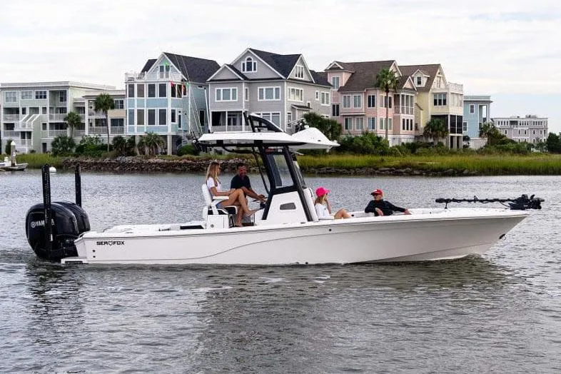 Slide: The Image of Manufacturer Provided Image: 2025 Sea Fox 282 Hybrid LT boat cruising near colorful waterfront homes. - 2