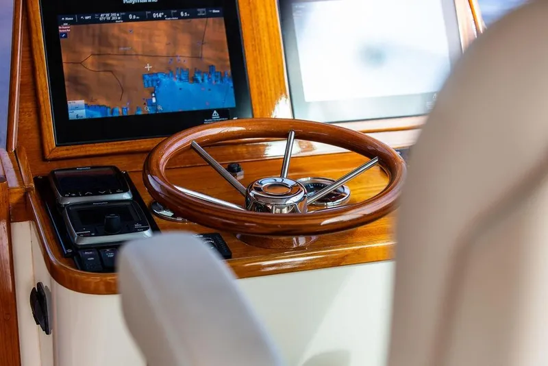 Slide: The Image of Helm of 2005 Hinckley Talaria 40 with wooden steering wheel and navigation display. - 13