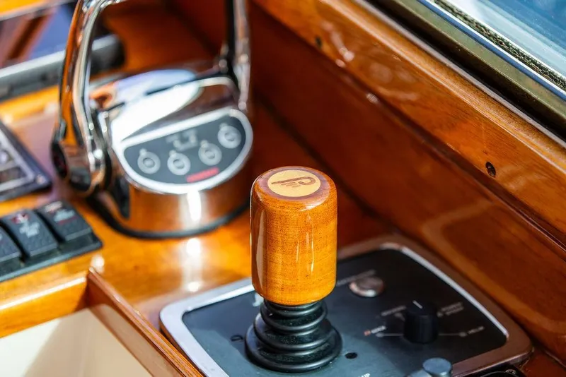 Slide: The Image of Hinckley Talaria 40 yacht controls, featuring a wooden throttle and modern dashboard, 2005 model. - 16