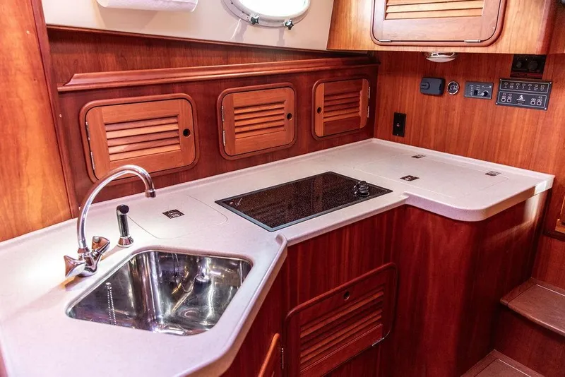 Slide: The Image of Luxurious 2005 Hinckley Talaria 40 yacht kitchen with wooden cabinetry and modern sink. - 30