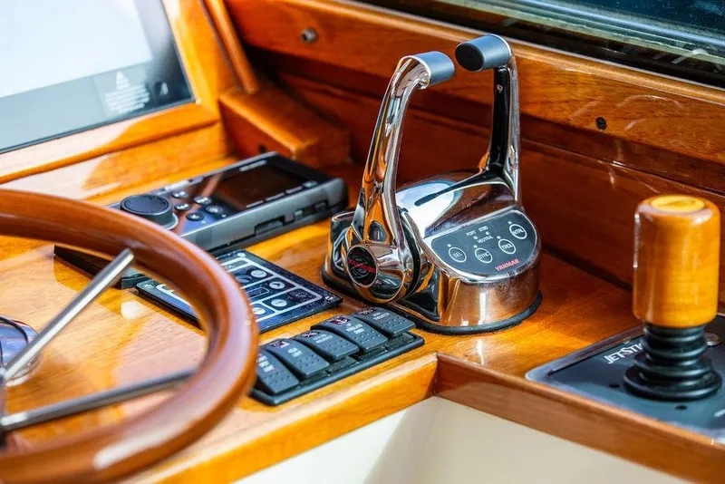 Slide: The Image of Helm controls of a 2005 Hinckley Talaria 40, featuring polished wood and modern instruments. - 17