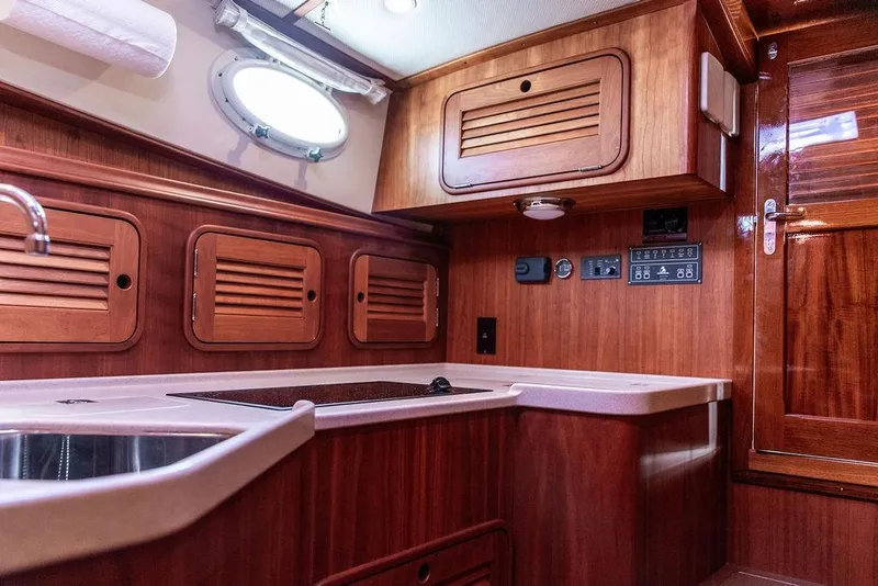 Slide: The Image of 2005 Hinckley Talaria 40 yacht interior with wooden cabinetry and modern kitchen amenities. - 31