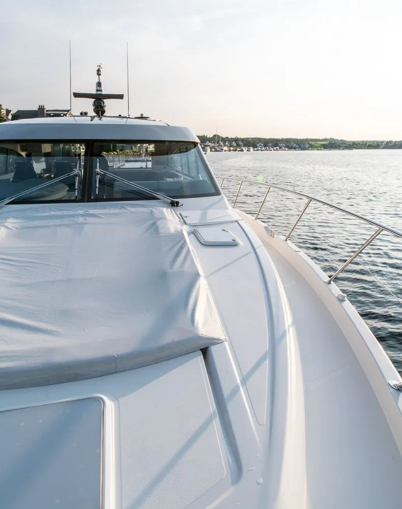 Slide: The Image of 2022 Riviera 6000 Sport Yacht Platinum on calm water, showcasing sleek design and luxury features. - 12