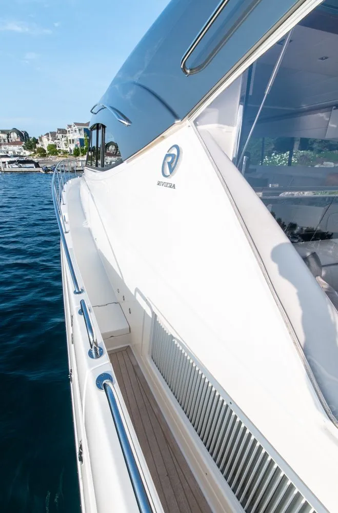 Slide: The Image of 2022 Riviera 6000 Sport Yacht Platinum on water, showcasing sleek design and luxury features. - 13