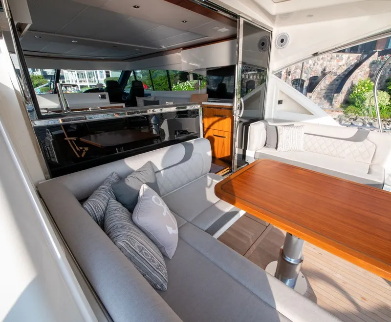 Slide: The Image of Luxurious interior of 2022 Riviera 6000 Sport Yacht Platinum with elegant seating and wooden table. - 19