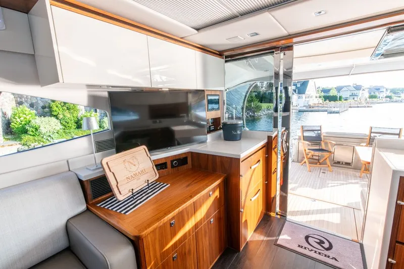 Slide: The Image of Interior of 2022 Riviera 6000 Sport Yacht Platinum with modern design and waterfront view. - 24