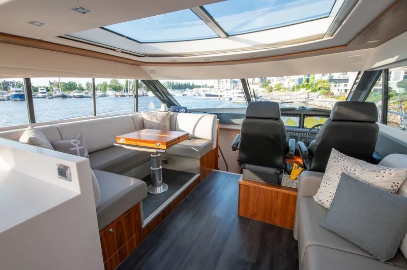 Slide: The Image of Luxurious interior of 2022 Riviera 6000 Sport Yacht Platinum with panoramic windows and plush seating. - 28