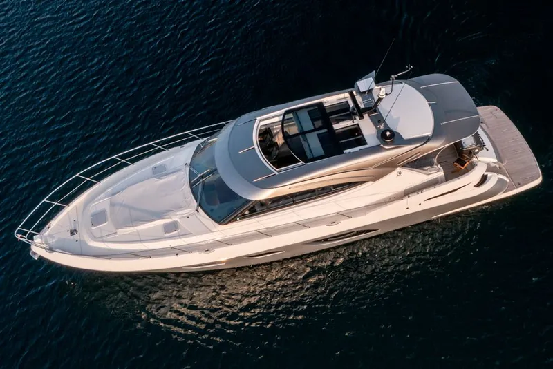 Slide: The Image of 2022 Riviera 6000 Sport Yacht Platinum cruising on open water, aerial view. - 3