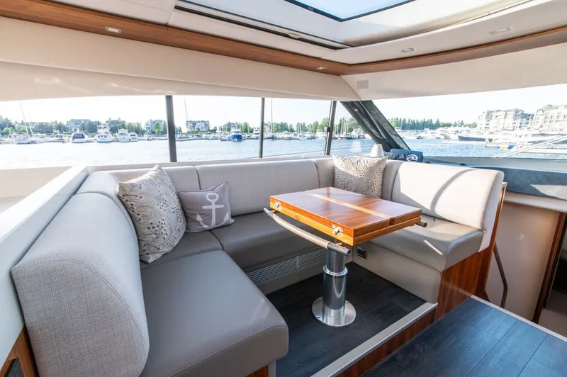 Slide: The Image of Luxurious interior of 2022 Riviera 6000 Sport Yacht Platinum with elegant seating and table. - 30