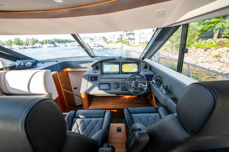 Slide: The Image of 2022 Riviera 6000 Sport Yacht Platinum helm with modern navigation displays and luxurious seating. - 38