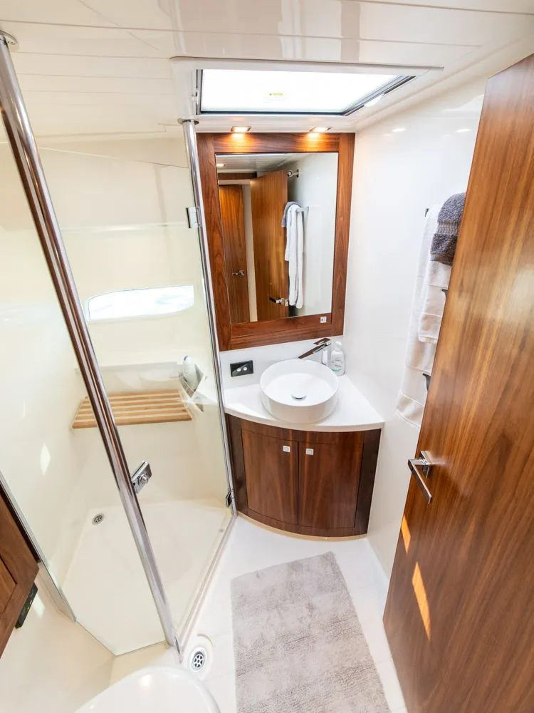 Slide: The Image of Luxurious bathroom in 2022 Riviera 6000 Sport Yacht Platinum with wood accents and modern fixtures. - 48