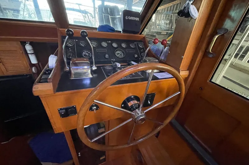 Slide: The Image of 1986 NOVA MARINE 36 Sundeck helm with wooden wheel and control panel. - 10
