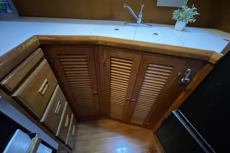 Slide: The Image of 1986 NOVA MARINE 36 Sundeck kitchen with wooden cabinets and countertop sink. - 2