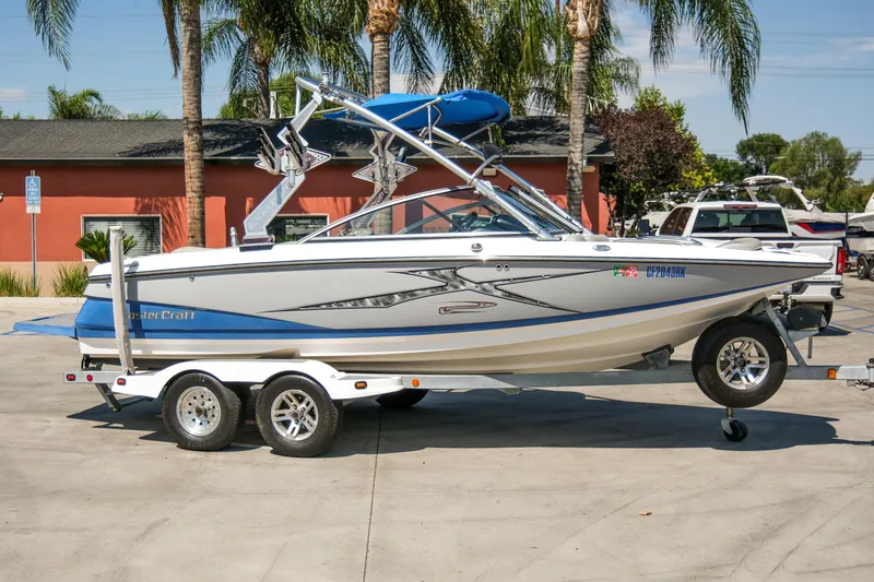 The Image of 2007 MasterCraft X-2 SS boat on trailer, parked outdoors with palm trees in background. - 0
