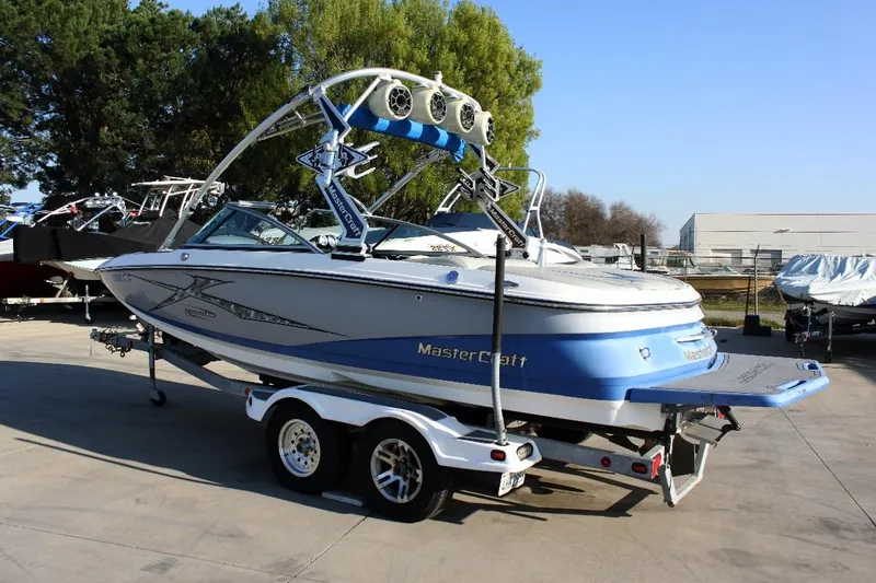 Slide: The Image of 2007 MasterCraft X-2 SS boat on trailer, blue and white, parked outdoors. - 1
