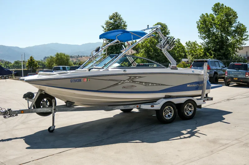 Slide: The Image of 2007 MasterCraft X-2 SS boat on trailer, parked outdoors with scenic mountain backdrop. - 10