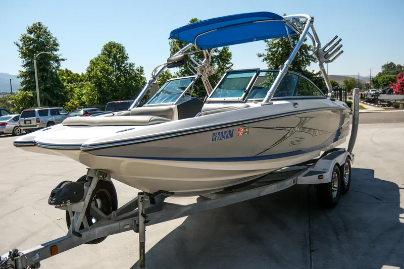 Slide: The Image of 2007 MasterCraft X-2 SS boat on trailer with blue canopy, parked outdoors. - 11
