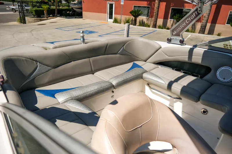 Slide: The Image of 2007 MasterCraft X-2 SS boat interior with gray and blue seating, outdoor setting. - 13