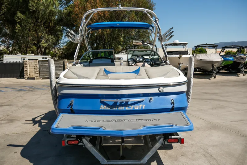 Slide: The Image of 2007 MasterCraft X-2 SS boat, blue and white, parked outdoors on a sunny day. - 15