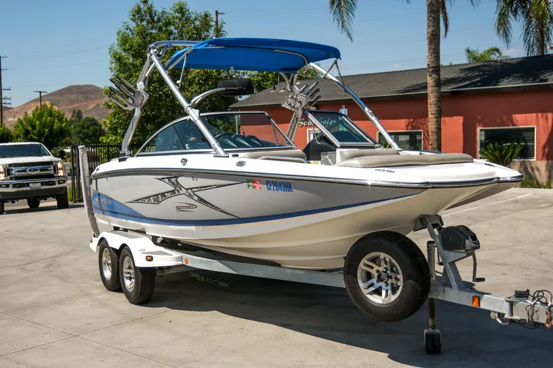 Slide: The Image of 2007 MasterCraft X-2 SS boat on trailer, parked outdoors with palm trees in background. - 25