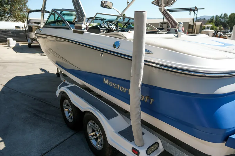 Slide: The Image of 2007 MasterCraft X-2 SS boat on trailer, blue and white design, parked outdoors. - 26
