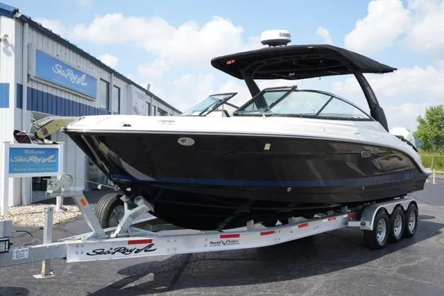 The Image of 2024 Sea Ray 280 SLX boat on trailer outside dealership, under clear blue sky. - 1