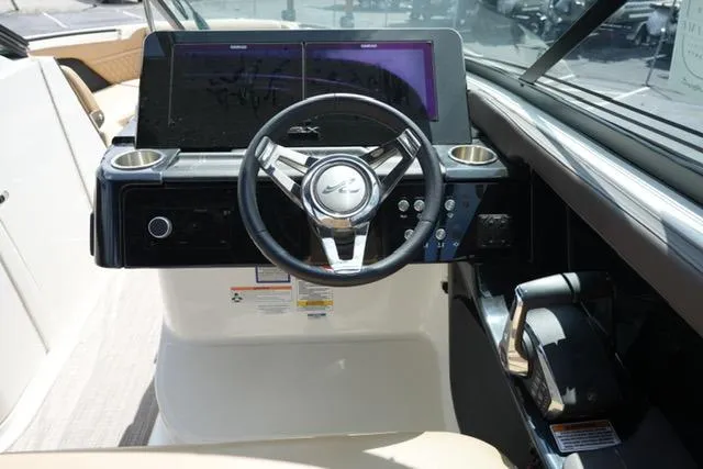 Slide: The Image of 2024 Sea Ray 280 SLX boat dashboard with steering wheel and dual screens. - 15