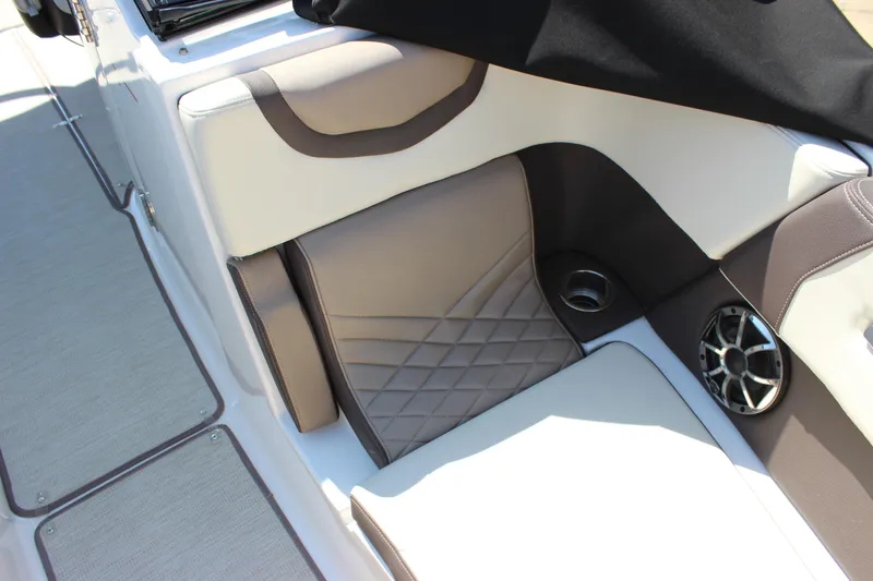 Slide: The Image of 2018 Chaparral 287 SSX boat interior with beige and white seating, speaker, and cup holder. - 12