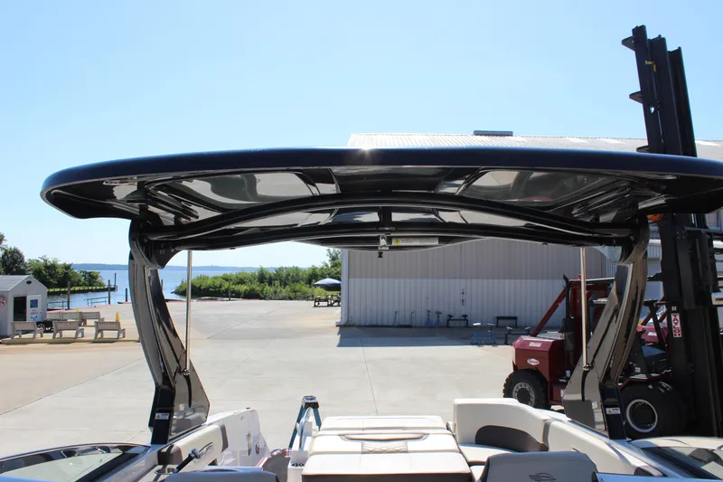 Slide: The Image of 2018 Chaparral 287 SSX boat with sleek black canopy, dockside view. - 14