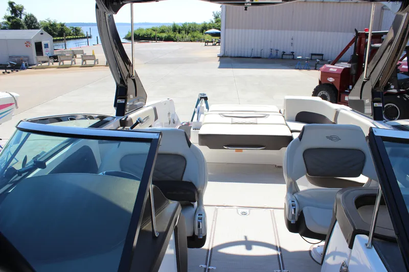 Slide: The Image of 2018 Chaparral 287 SSX boat interior with seating, docked near a waterfront. - 15