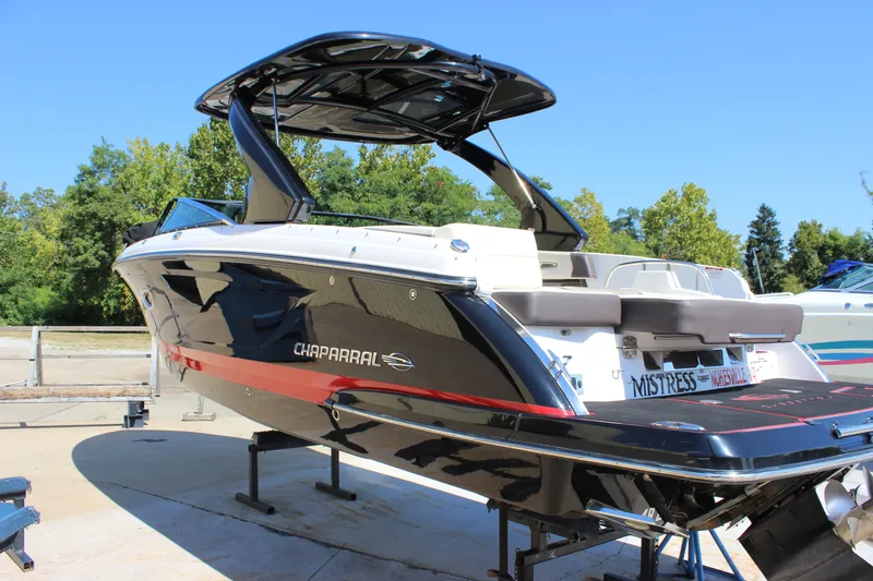 Slide: The Image of 2018 Chaparral 287 SSX boat on display, featuring sleek black and red design. - 2