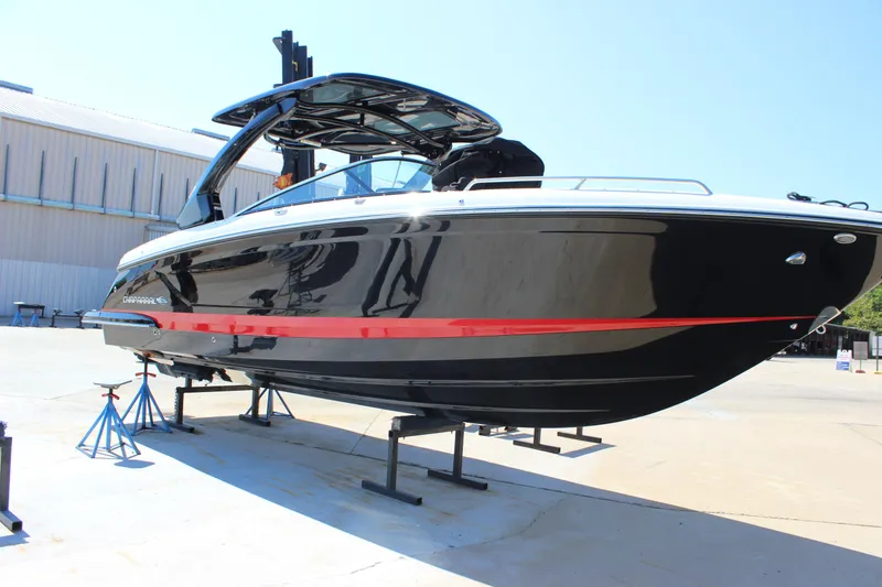 Slide: The Image of 2018 Chaparral 287 SSX boat on stands, black with red stripe, outdoor display. - 3
