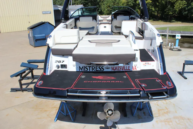 Slide: The Image of 2018 Chaparral 287 SSX boat with spacious seating and sleek design, docked outdoors. - 4