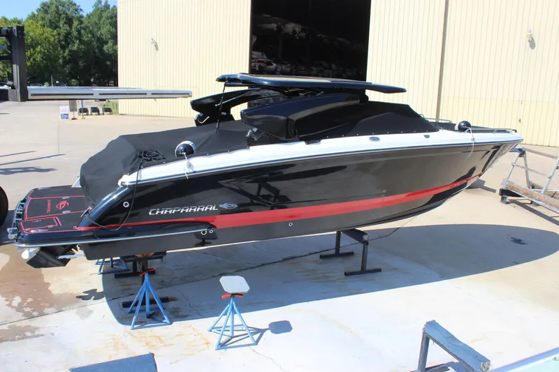 Slide: The Image of 2018 Chaparral 287 SSX boat in black with red accents, docked outdoors. - 42