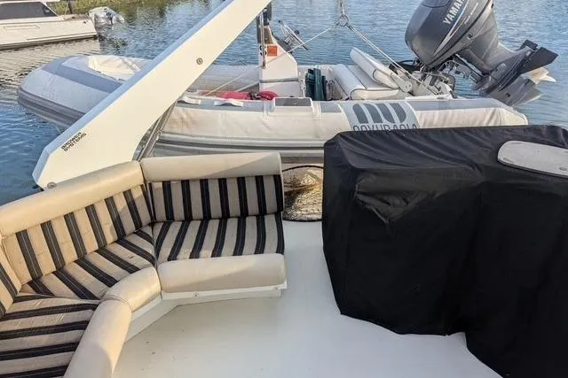 Slide: The Image of Luxury Navigator 57 yacht deck with striped seating and inflatable boat, 2004 model. - 13