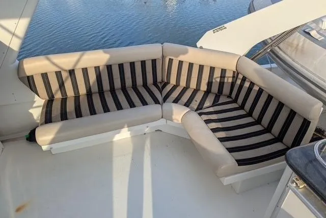 Slide: The Image of 2004 Navigator 57 yacht with striped seating on deck, overlooking water. - 15