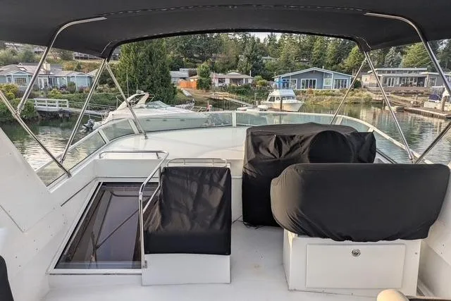 Slide: The Image of 2004 Navigator 57 yacht deck with covered seating, overlooking a serene waterfront community. - 16