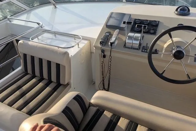 Slide: The Image of 2004 Navigator 57 yacht helm with striped seating and control panel. - 17