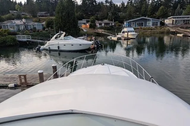 Slide: The Image of 2004 Navigator 57 yacht docked in a serene marina with surrounding houses and trees. - 19