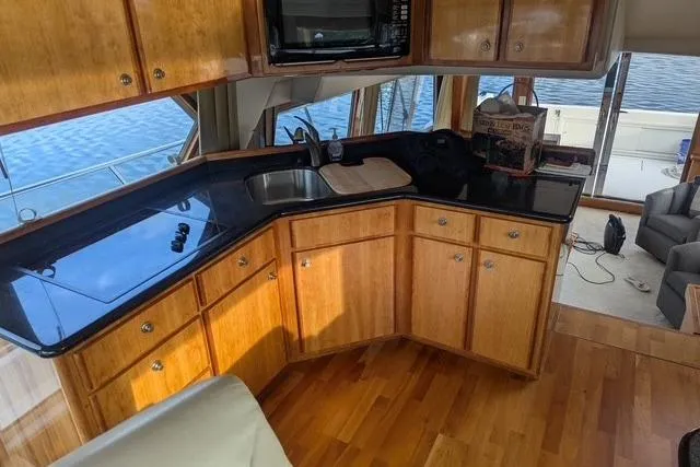 Slide: The Image of Luxurious 2004 Navigator 57 yacht interior with wooden cabinetry and sleek black countertops. - 3