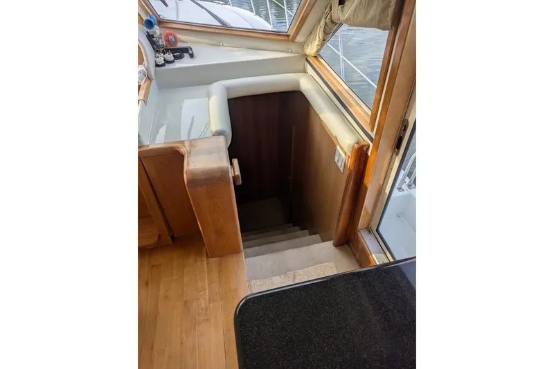 Slide: The Image of Staircase inside 2004 Navigator 57 yacht, featuring wooden interior and window view. - 5
